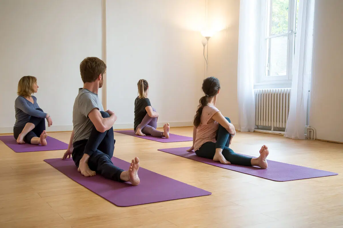 Groupe d'élèves en torsion assise lors d'un cours de yoga à Lyon Croix-Rousse