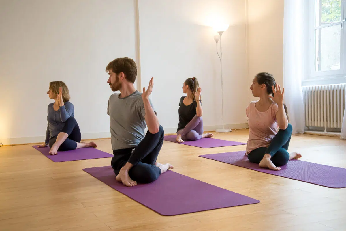 Élèves en torsion assise pendant un cours de hatha yoga à Lyon Croix-Rousse