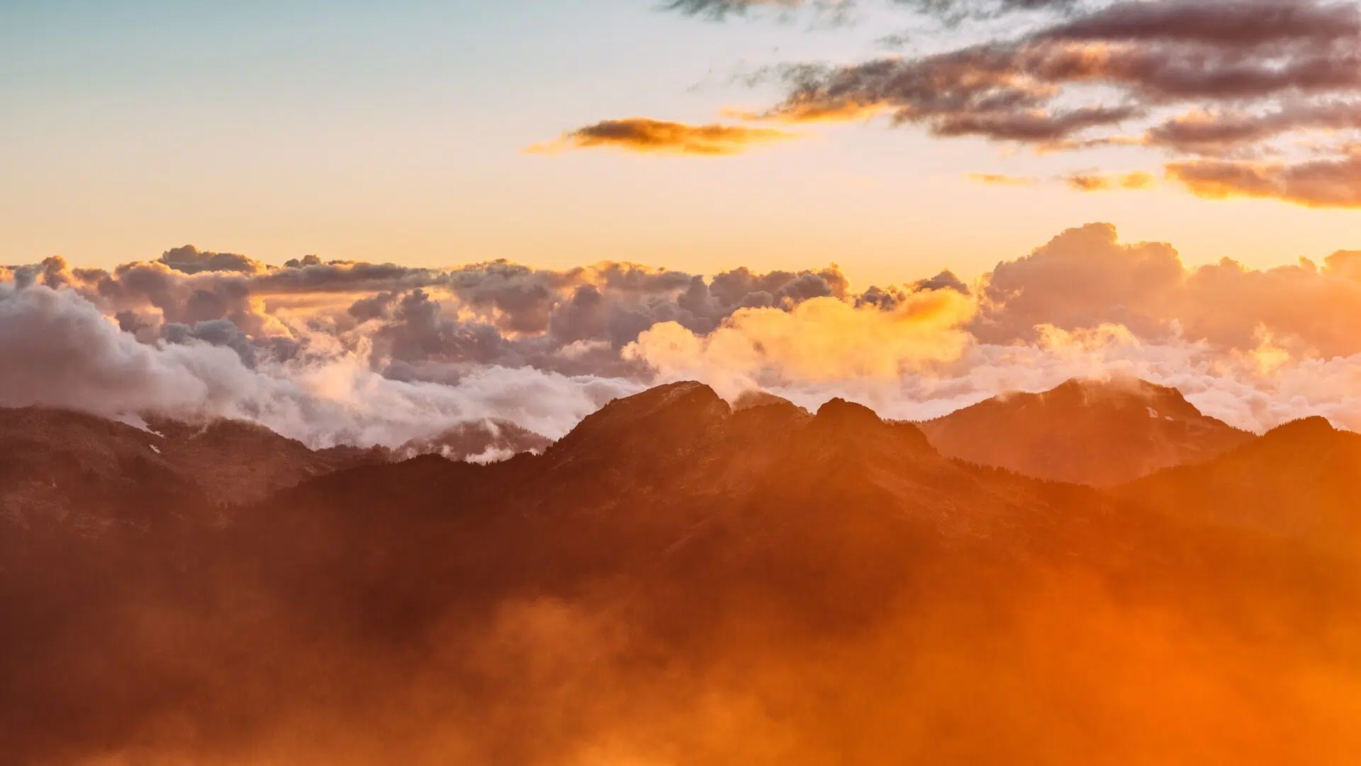 Lever de soleil sur une mer de nuages au-dessus des montagnes