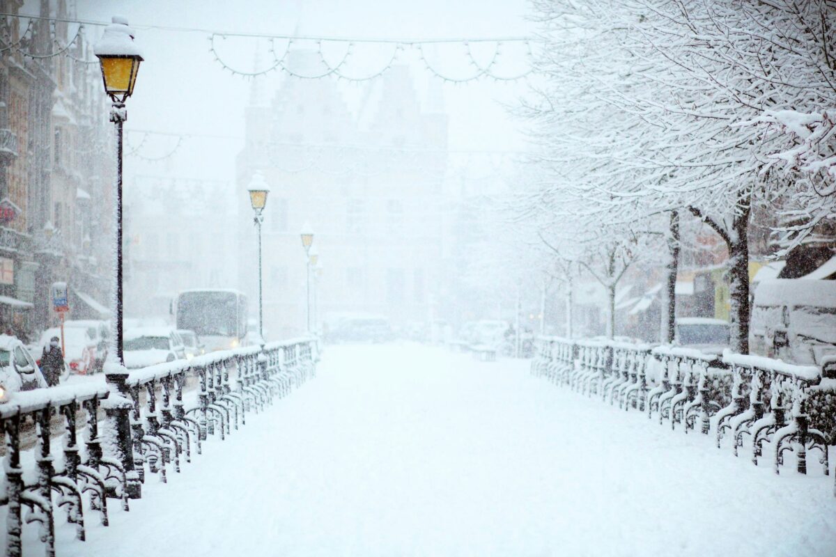Rue enneigée bordée de lampadaires et de grilles en hiver