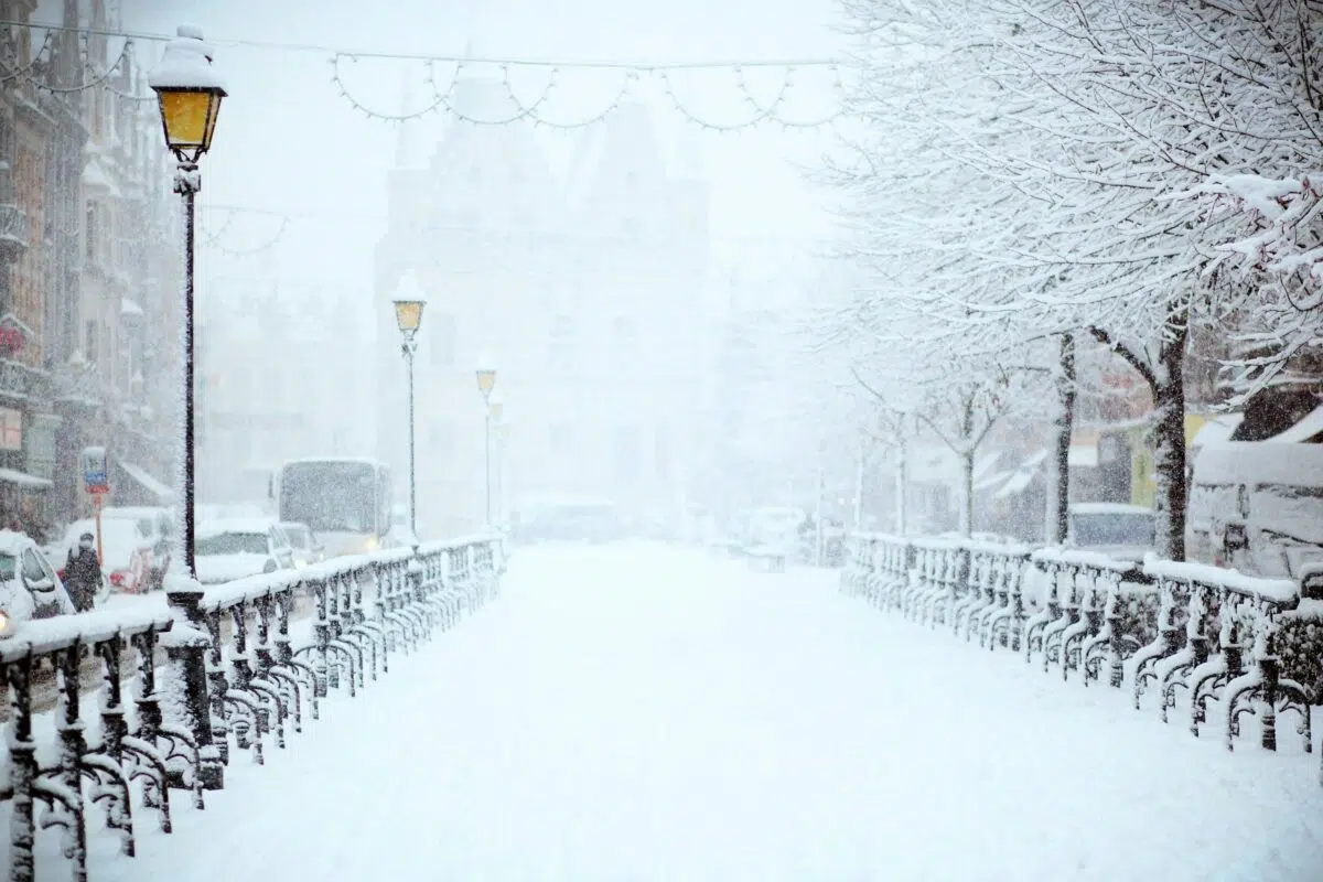 Rue enneigée bordée de lampadaires et de grilles en hiver