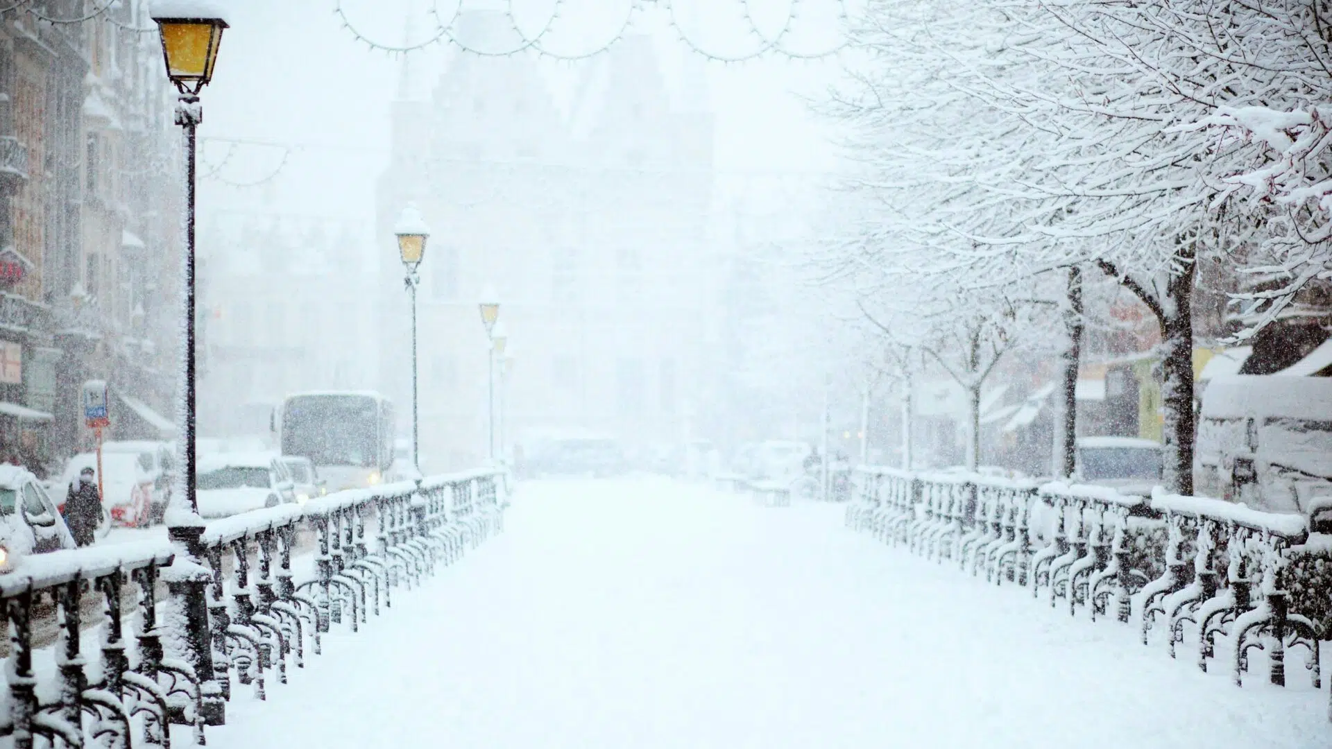 Rue enneigée bordée de lampadaires et de grilles en hiver