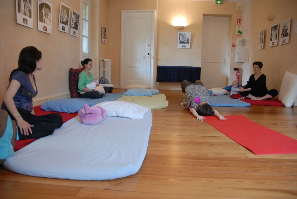 Jeunes mamans et leurs bébés sur des matelas, lors d'un cours de yoga post-natal